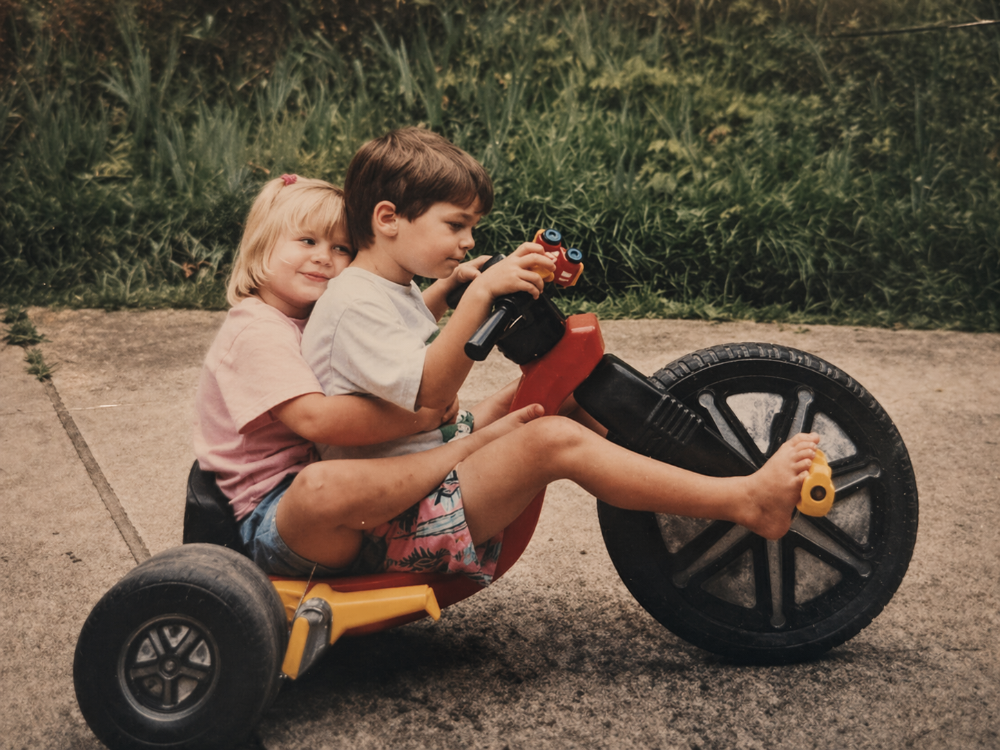 gvb founder, Jen, riding tricycle outside with brother outside grandparents house in Franklin, Tennessee
