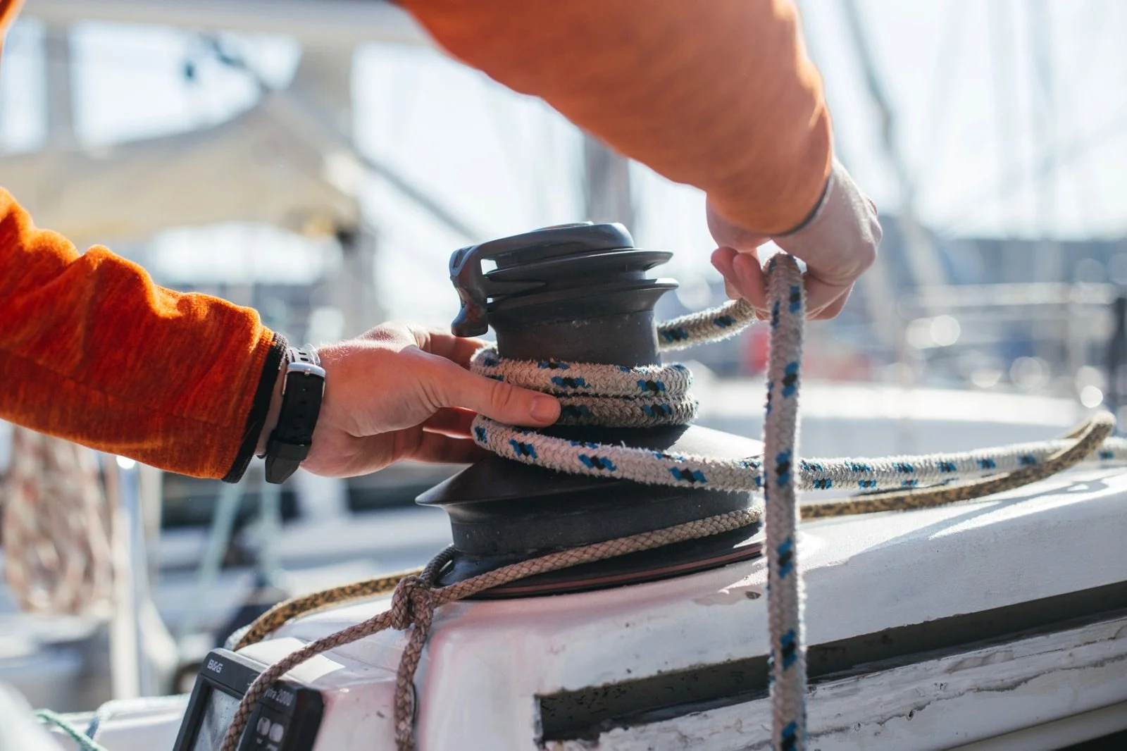 Hands securing a sailboat's winch with a rope at Up The Creek Marina, Bayville NJ.