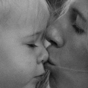 Close-up of a mom and daughter sharing a kiss. Authentic family photography shot on film.