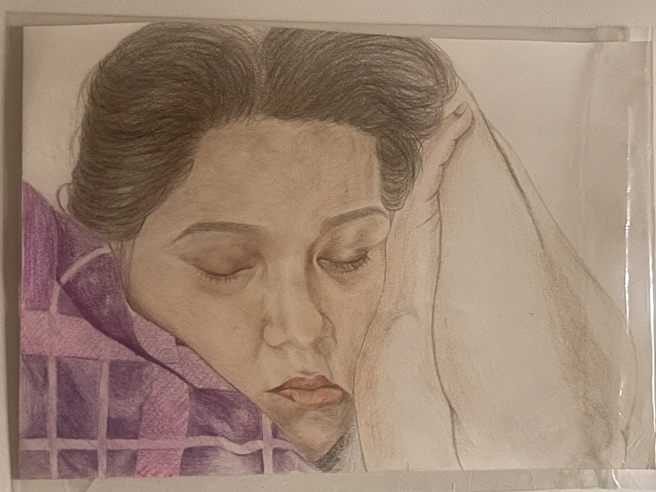 Colorful drawing of a woman with closed eyes, resting her head on a surface, with detailed hair and facial features, rendered in soft colors.