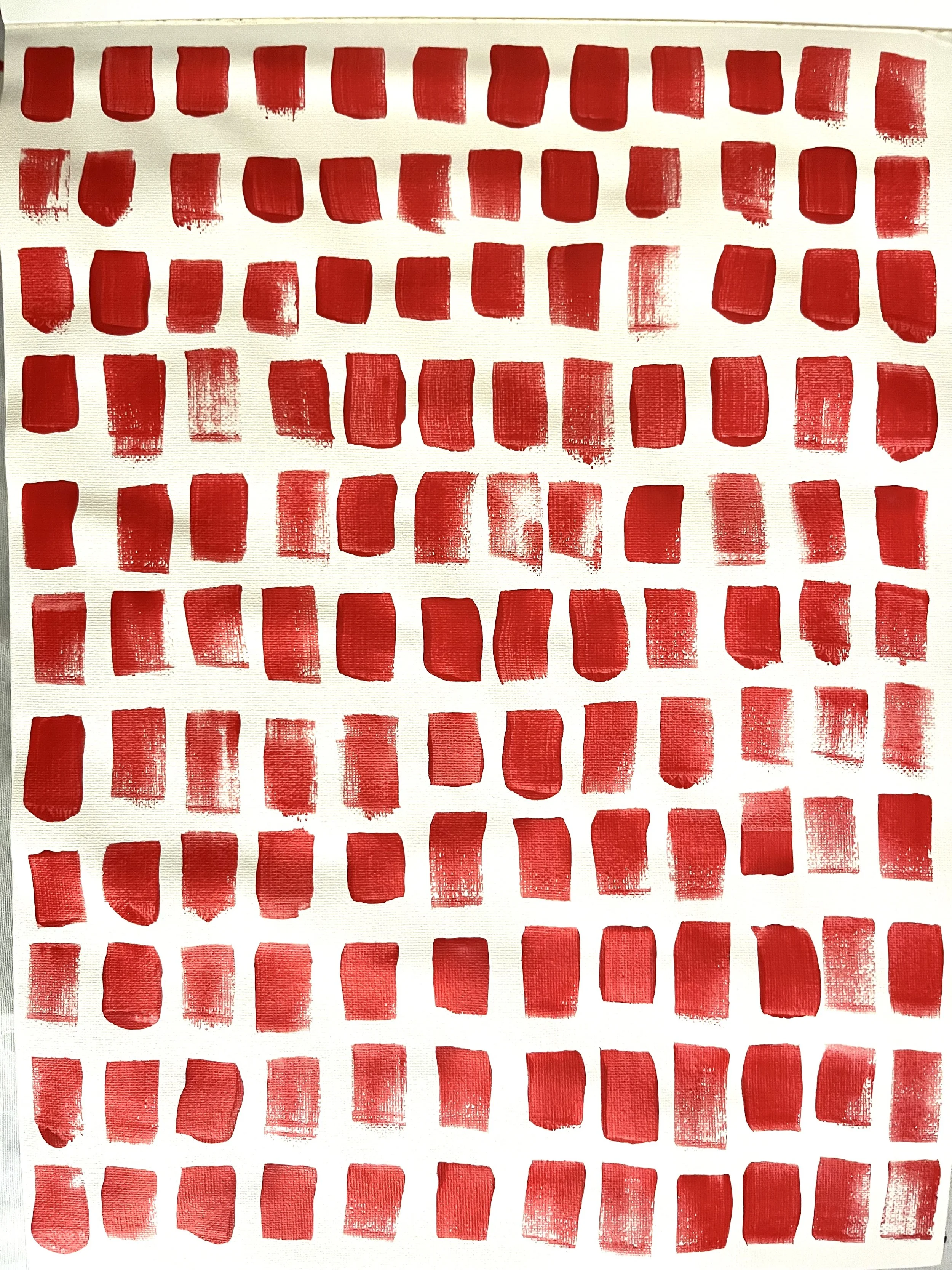 A sheet of paper with rows of red paint swatches in various rectangular and square shapes.