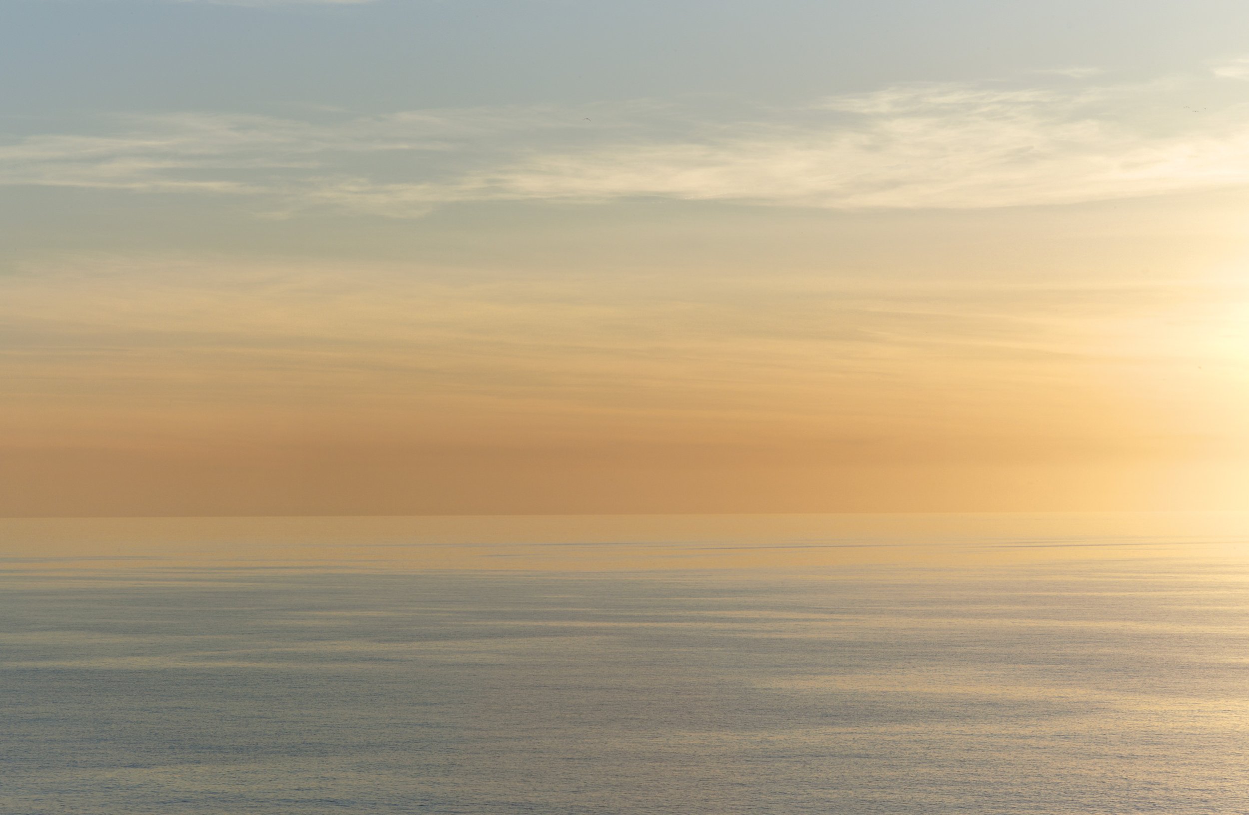 Un paysage marin avec un ciel nuageux et une surface d'eau calme, avec des tonalités pastel de jaune, bleu et gris.
