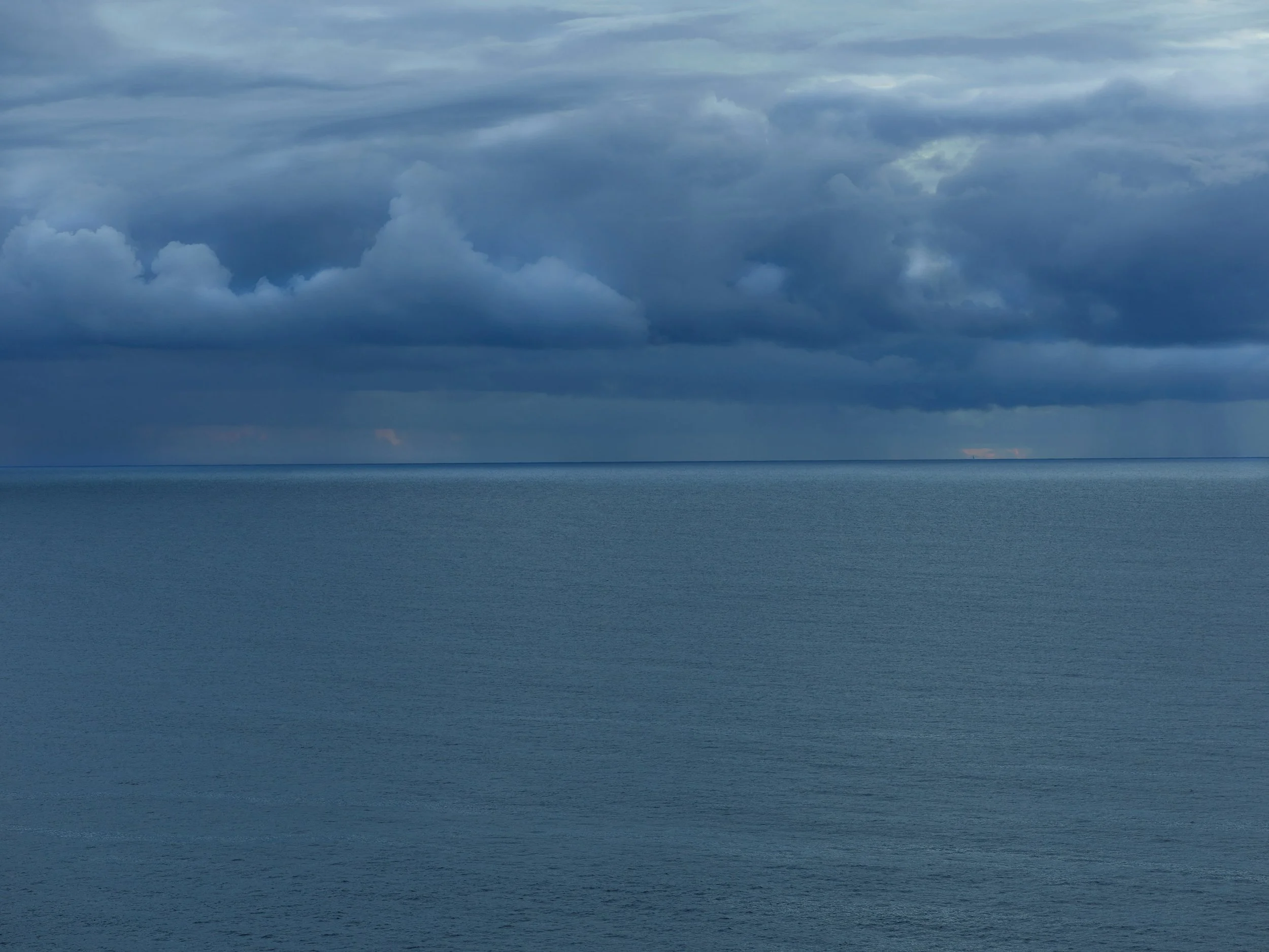 Ciel nuageux au-dessus d'une mer calme.