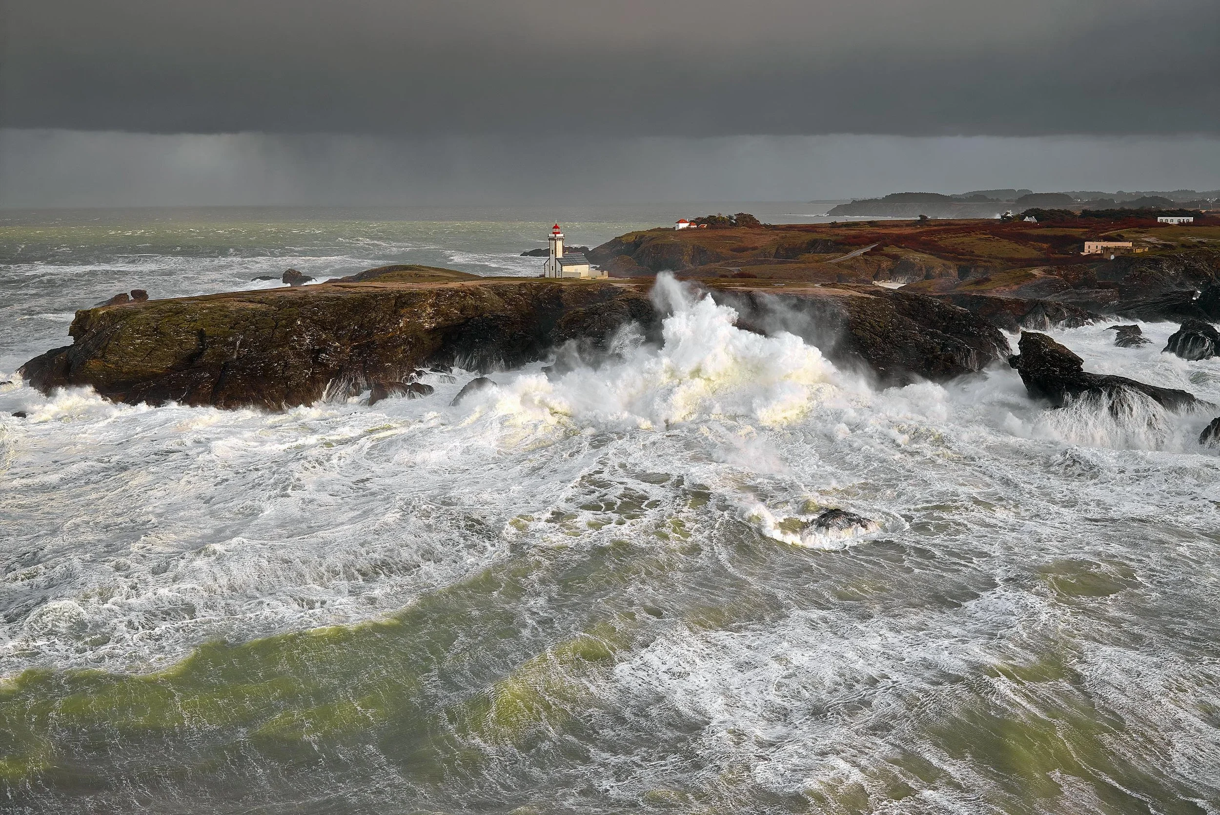 Phare sur une falaise, vagues déchaînées, ciel sombre, ciel orageux.