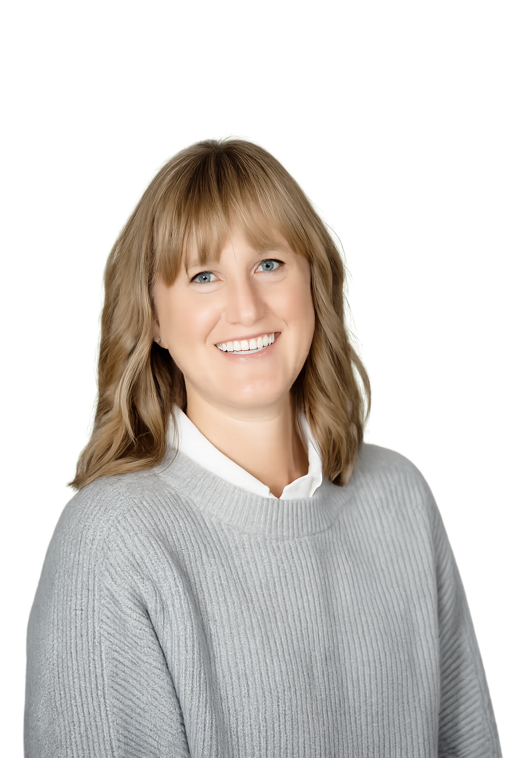 A woman with shoulder-length light brown hair and blue eyes smiling, wearing a light gray sweater and white shirt, against a white background.