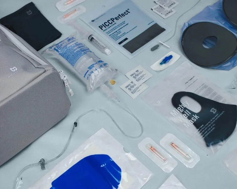 COVID-19 vaccination supplies on a table, including syringes, face masks, alcohol swabs, and informational pamphlets.