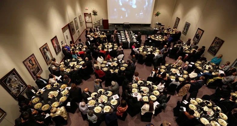 Event space at the Bruce R. Watkins Cultural Heritage Center set for a formal banquet with round tables and projection screen