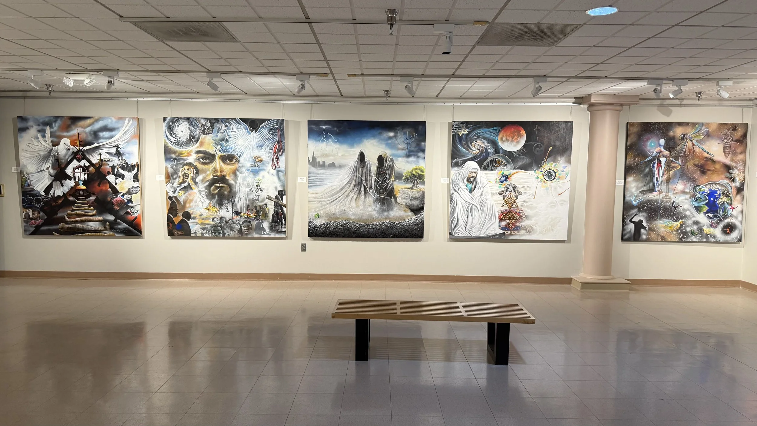 Art gallery displaying five large, colorful murals with abstract, spiritual, and cosmic themes on a white wall in an indoor setting.