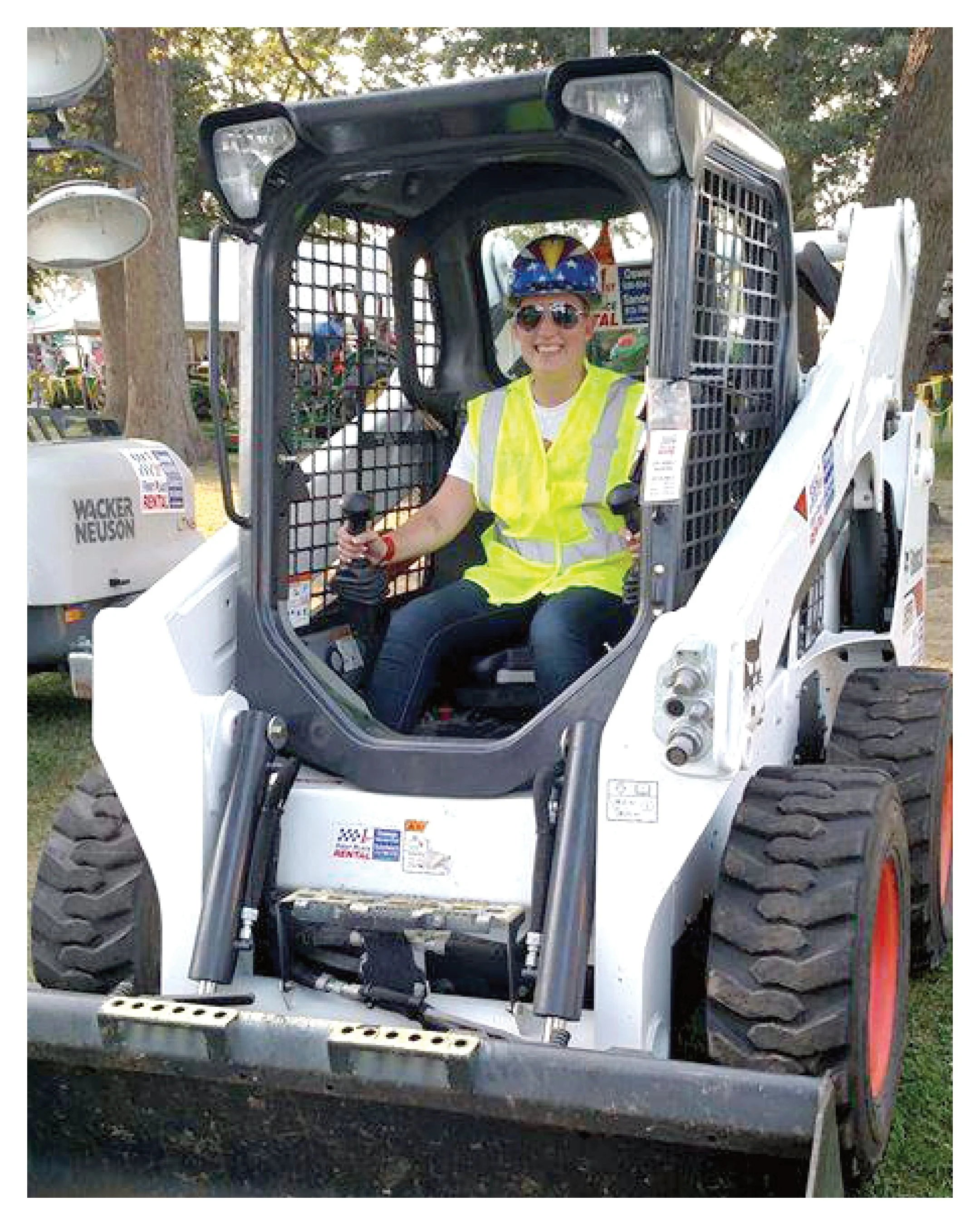 An employee of First Place Rental operating a skid-steer.