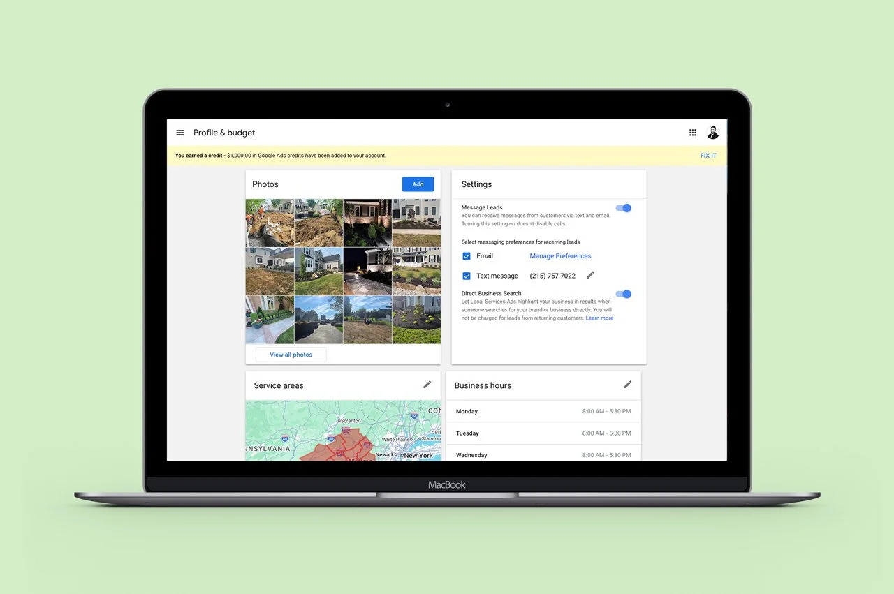Open MacBook on a light green background displaying a Google My Business profile with photos, service areas, and business hours.
