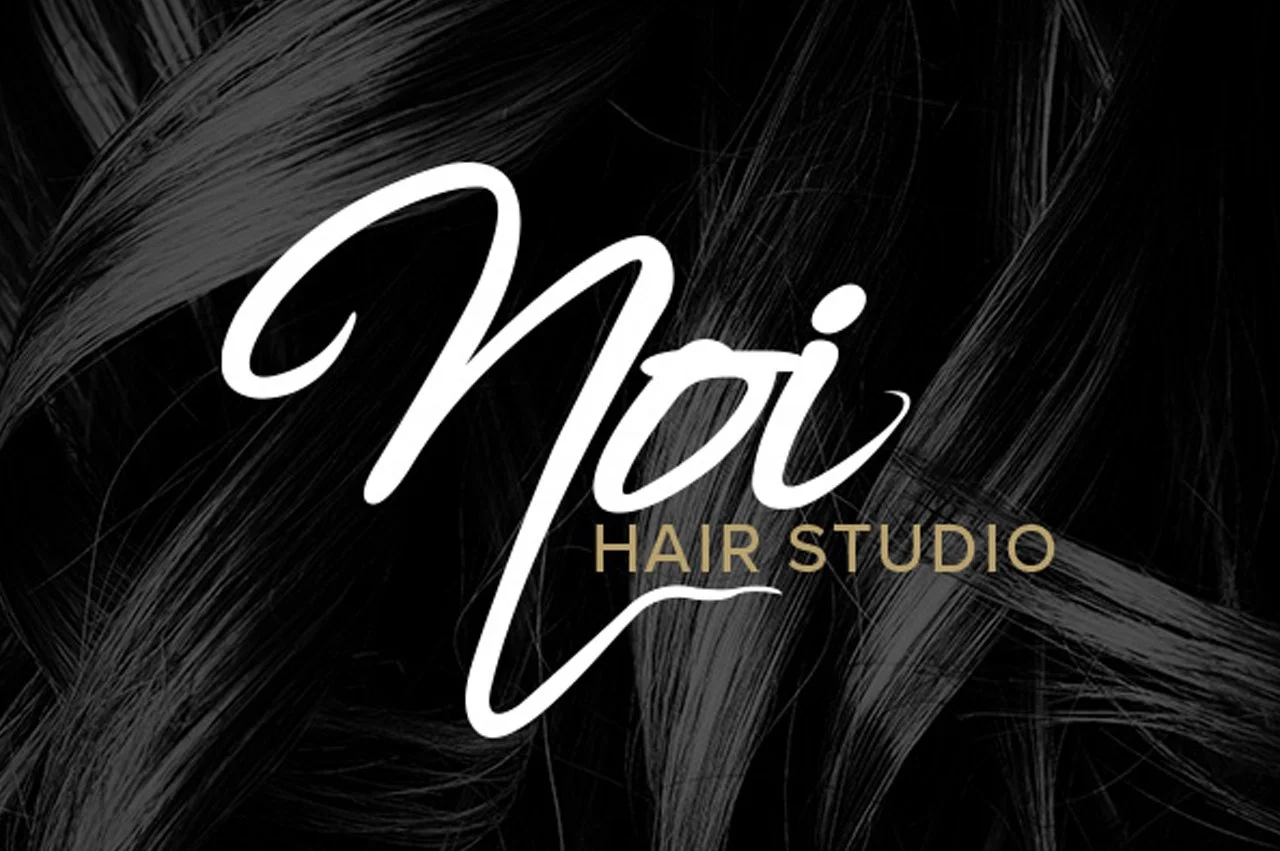 Logo for Noi Hair Studio with black background and stylized white and gold text