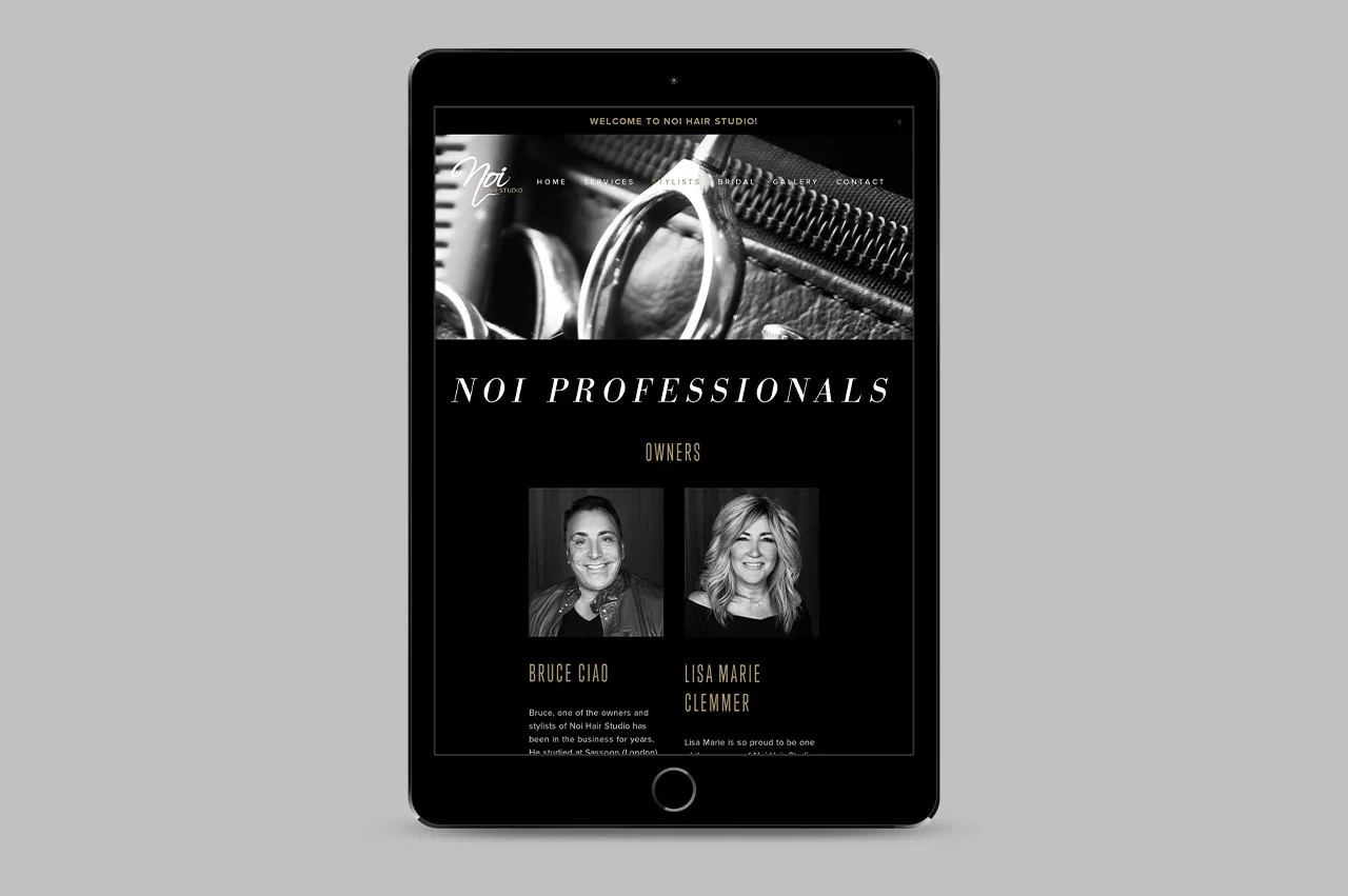 This is a grayscale website on a tablet featuring the hair salon Noi Hair Studio. The page introduces the professionals, Bruce Ciao and Lisa Marie Clemmer, with photos and descriptions of their roles.