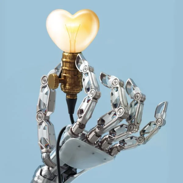 A robotic hand holding a light bulb shaped like a heart, symbolizing innovation and love.