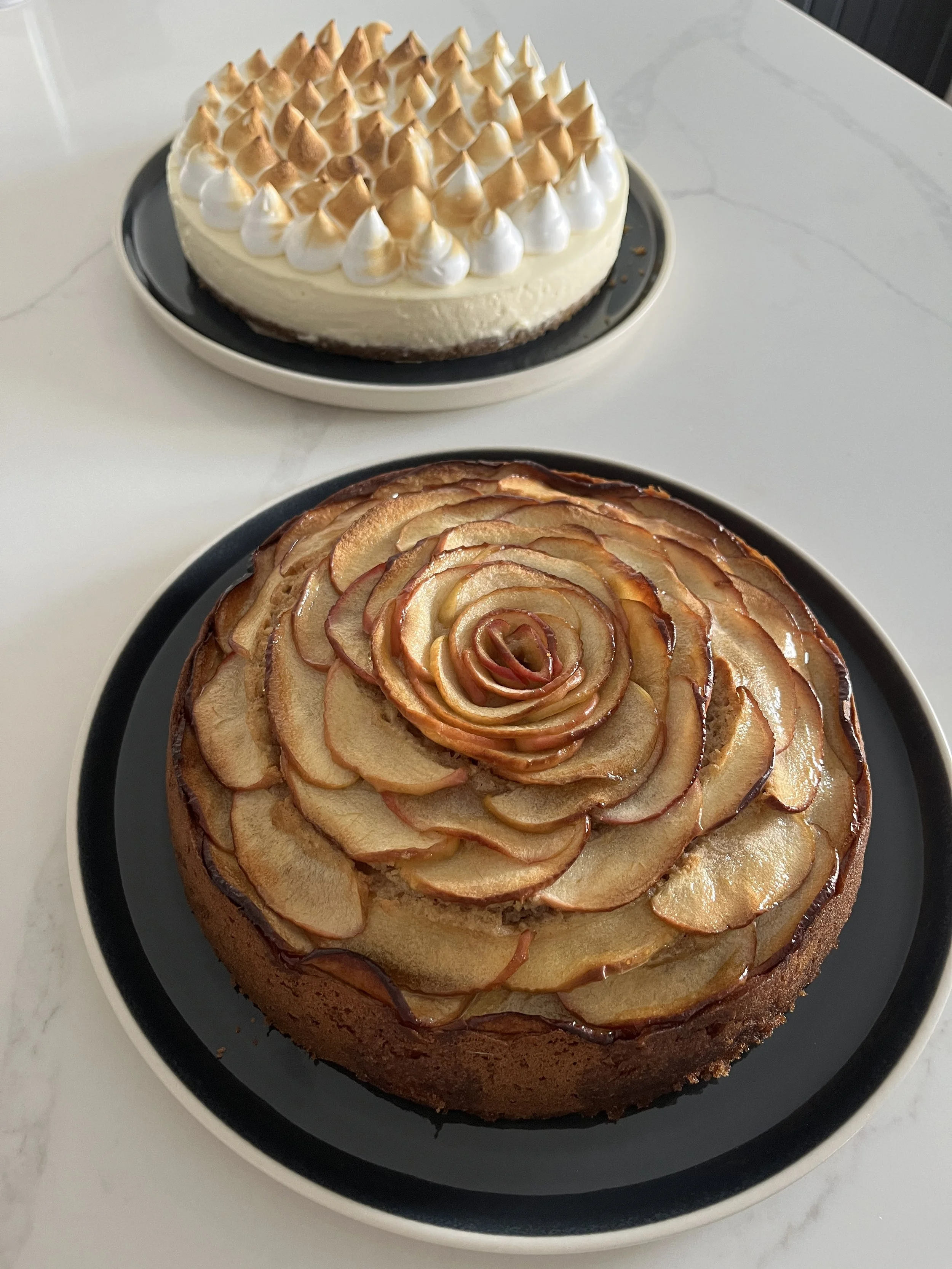 A round apple tart topped with thinly sliced apples arranged in a rose pattern.