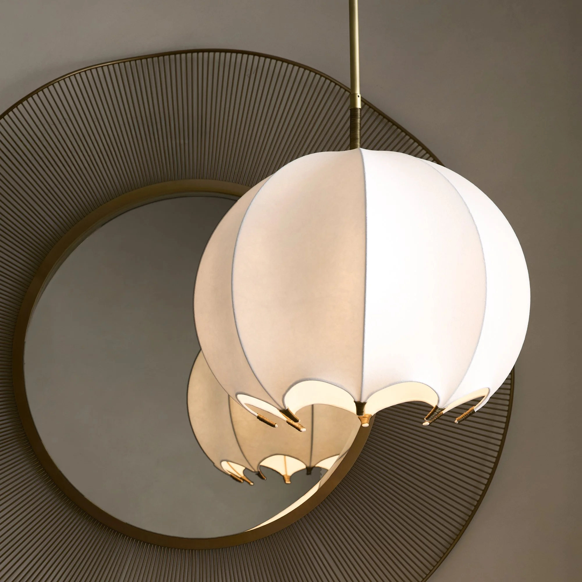 Close-up view of an elegant ceiling light fixture resembling a lantern, hanging from a circular, textured ceiling with concentric ridges.