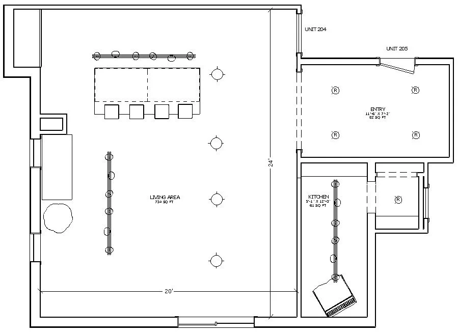 A floor plan of a residential living space showing an entry, kitchen, and large living area with furniture and fixtures.