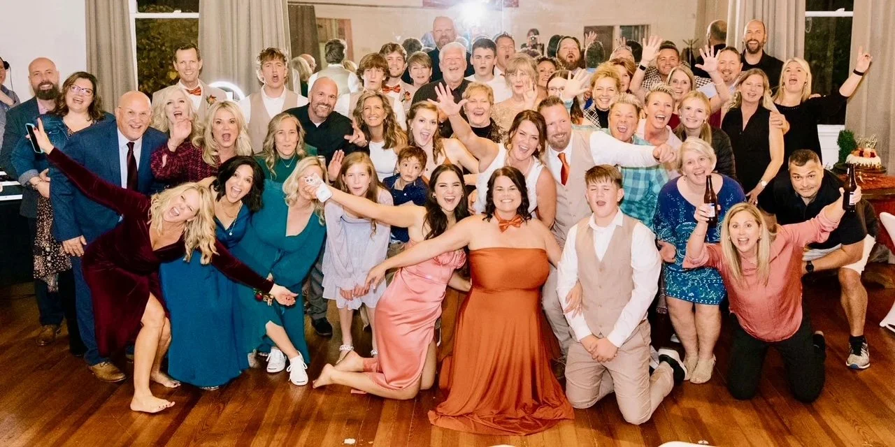 Large group of people celebrating at a party, smiling, posing, and having fun indoors.