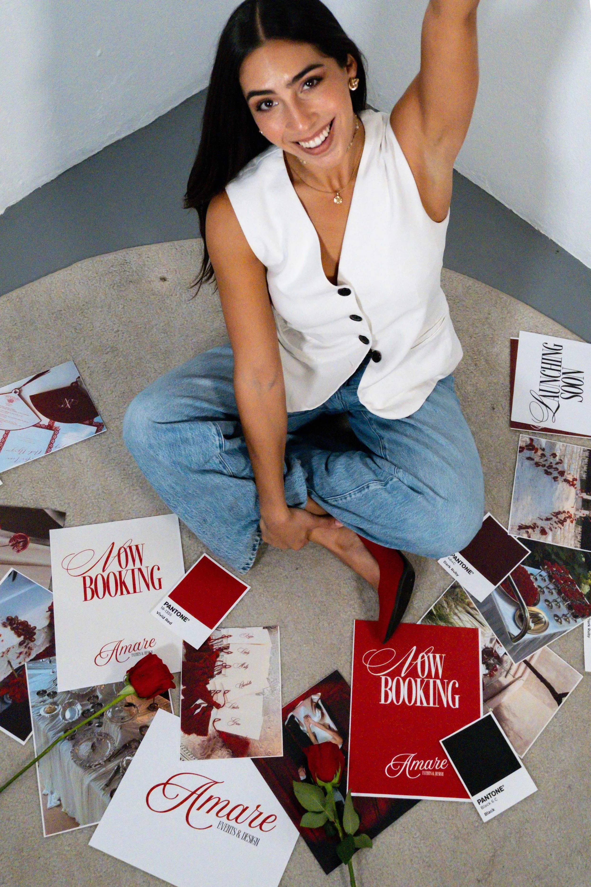 Amanda Rojas, founder of Amare Events & Design, surrounded by wedding design inspiration, branding materials, and wedding creative concepts