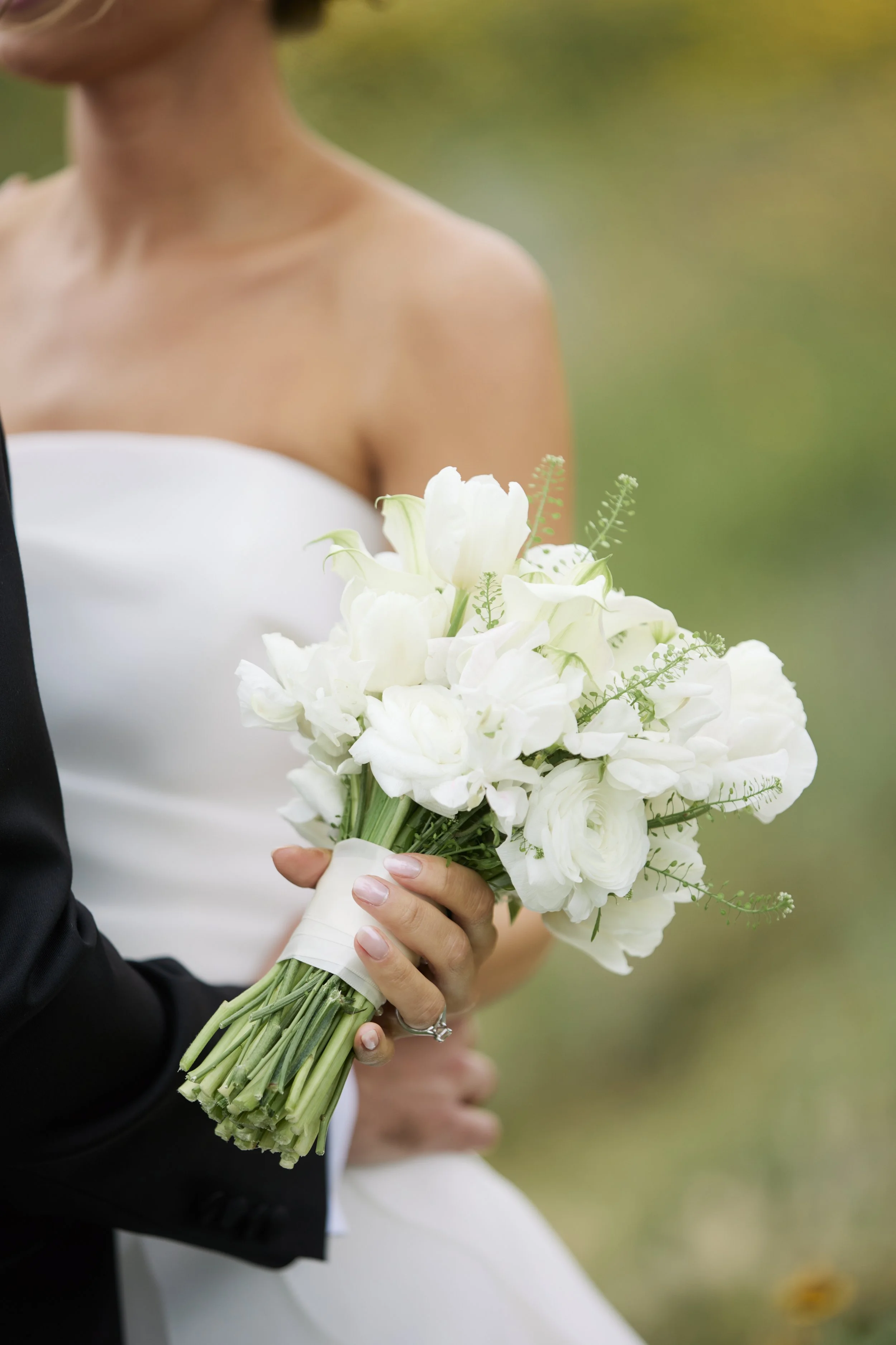 Close-up of a bride holding a white floral bouquet.