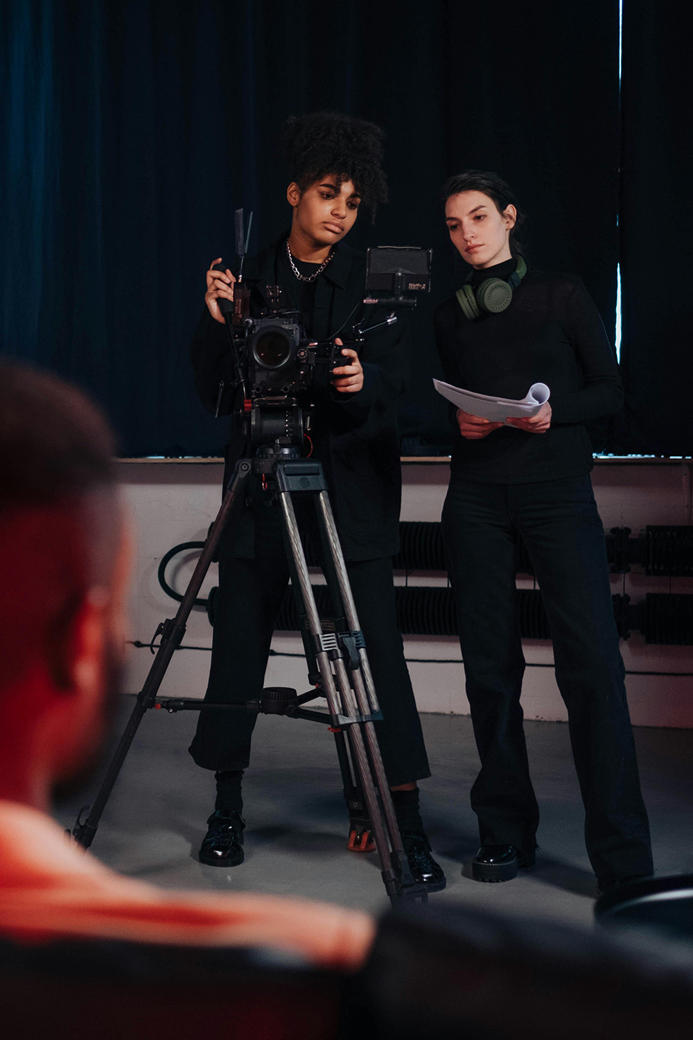 female film director reviewing script with female camera operator