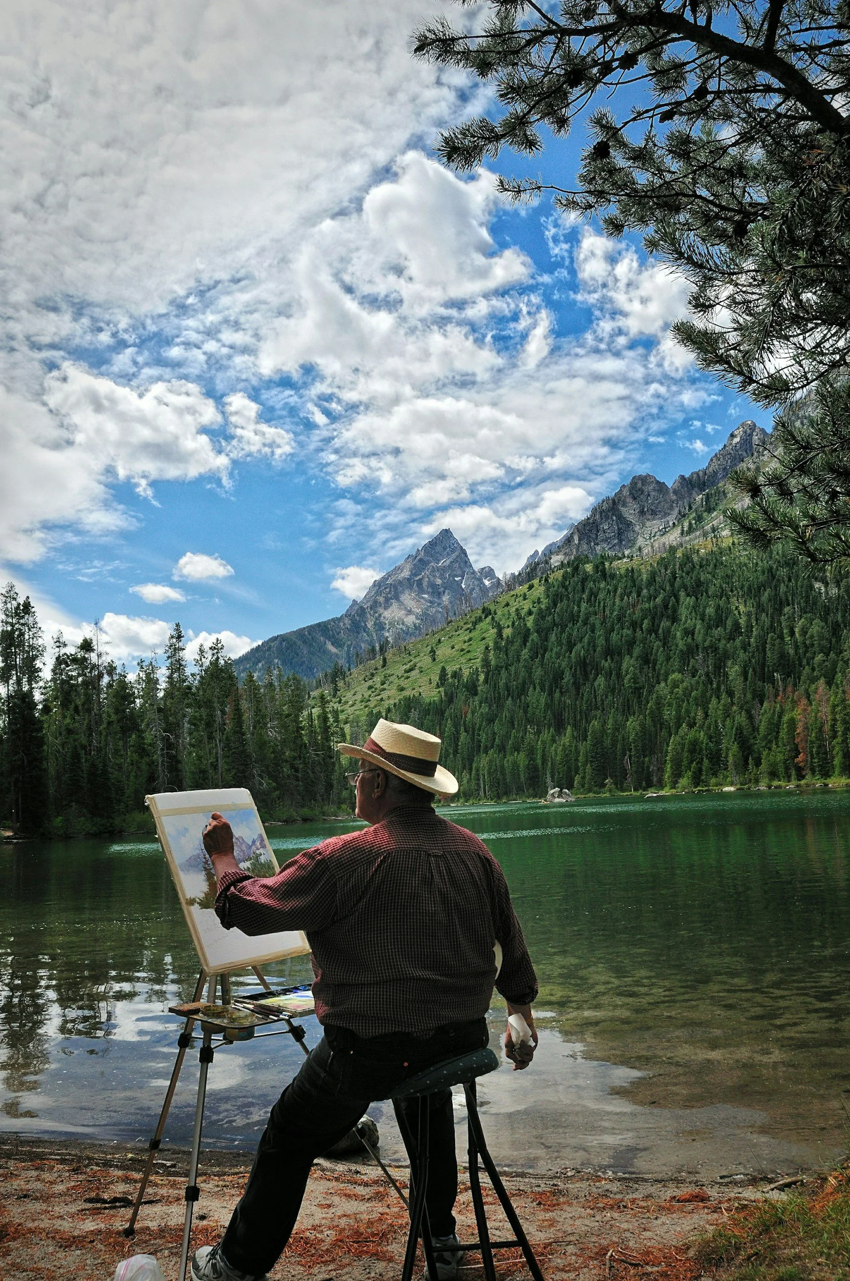 Mountain landscape with blue sky and forested slopes, representing the outdoor setting for plein‑air workshops