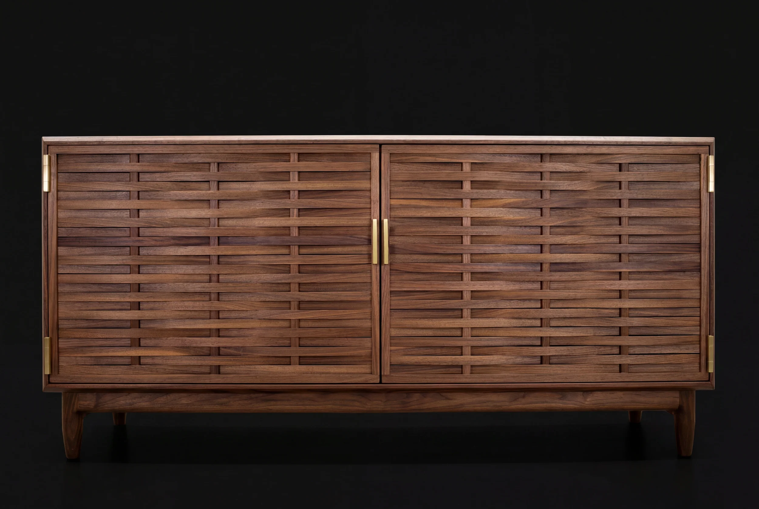 A wooden cabinet with a slatted front and gold handles, set against a black background.