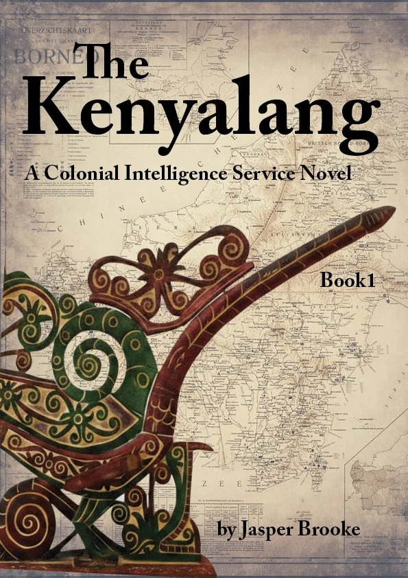 Book cover titled 'The Kenyalang: A Colonial Intelligence Service Novel, Book 1' by Jasper Brooke. The background features an old map of Borneo, with a decorative wooden carving of a hornbill bird in the foreground.
