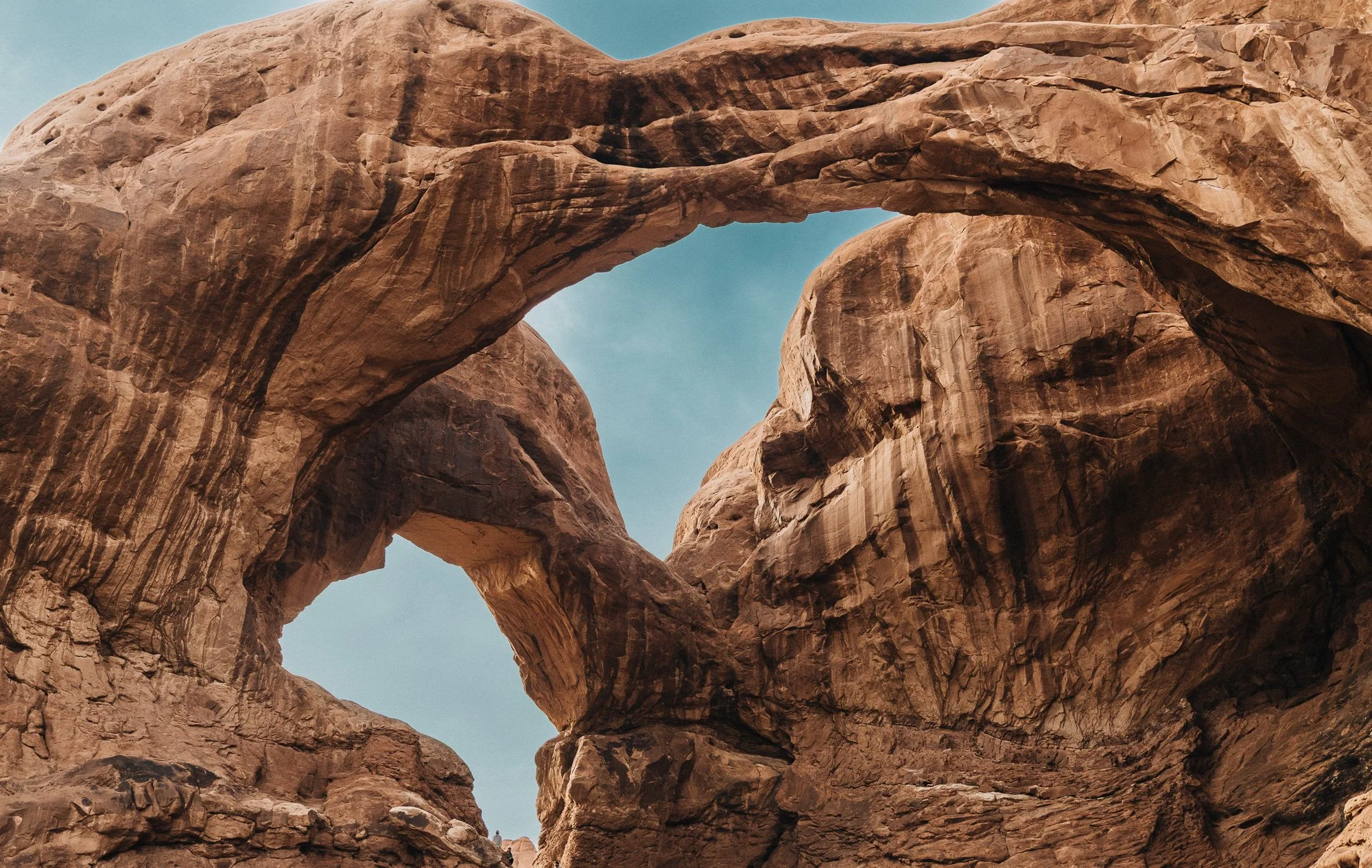 Arches National Park, Utah. Double Arch rock formation in a desert landscape under a clear sky.