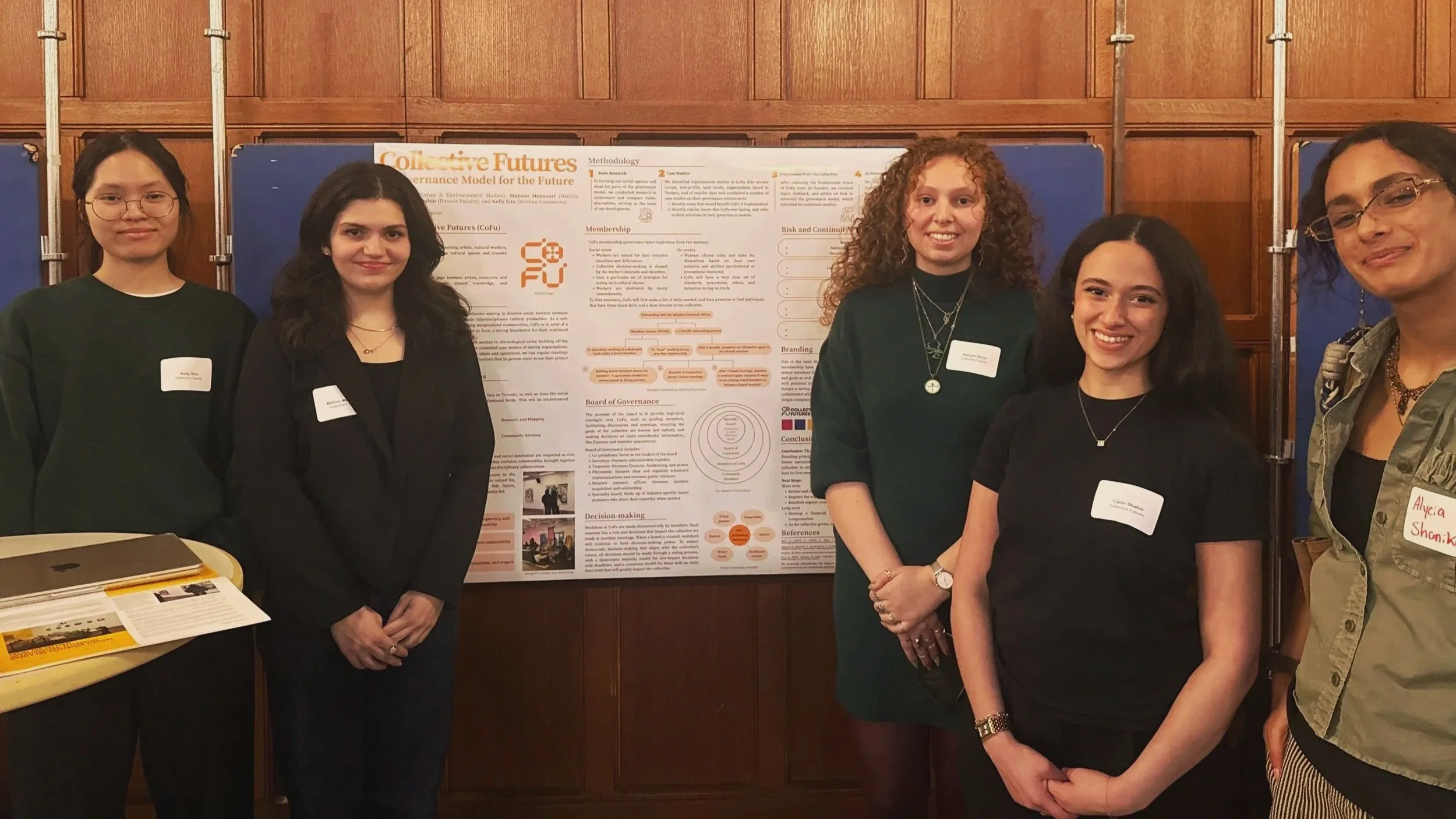 Six young women standing in front of a research poster at an academic event, all smiling for the photo.