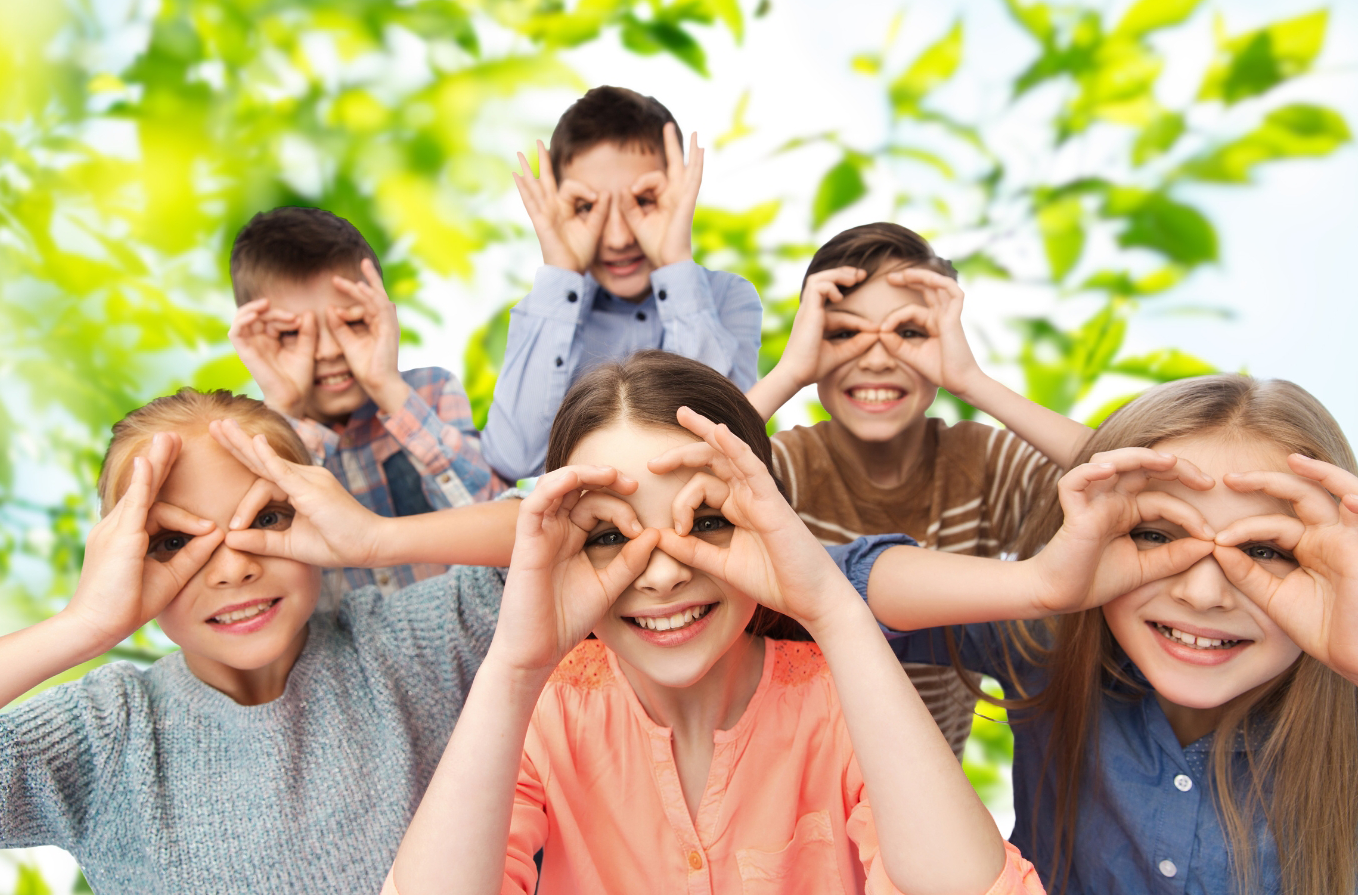 Gruppe von sechs fröhlichen Kindern, die durch die Fensterlinse schauen, während sie die Hände um die Augen formen, als ob sie nach etwas suchen, vor einem grünen Blätterhintergrund.