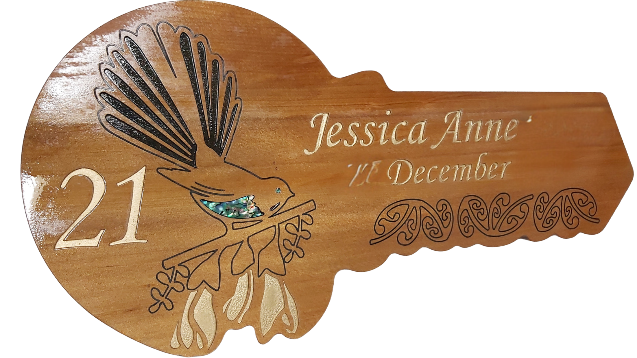 Wooden plaque with engraved text reading 'Jessica Anne, 17 December', decorated with a black outline of a bird and decorative patterns with iridescent inlays.
