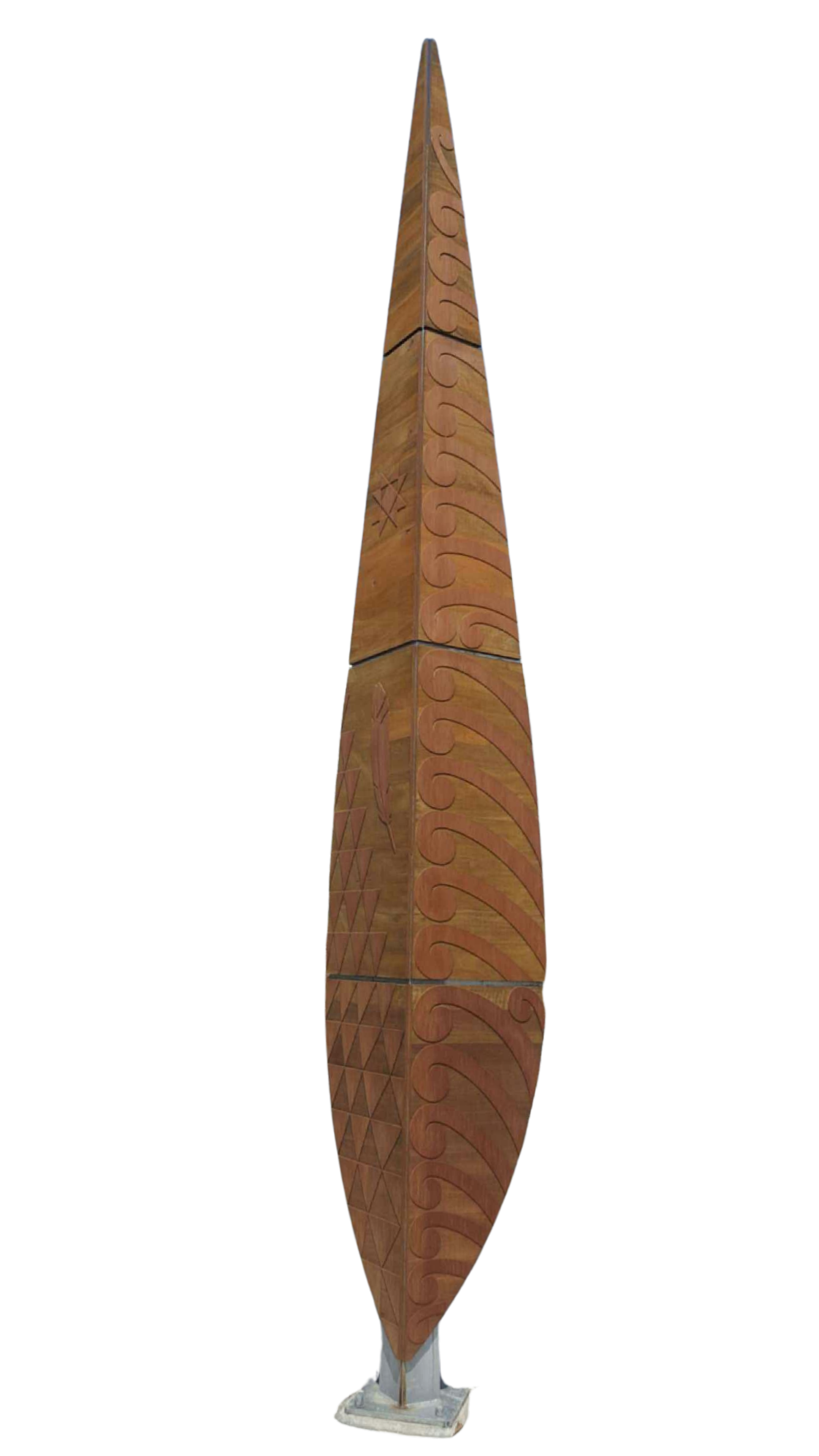 A tall carved wooden totem pole with intricate swirling patterns and geometric designs, mounted on a stone base.