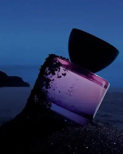Two bowls stacked on a beach at dusk, with one bowl tilted on the ground and the other balanced on top.