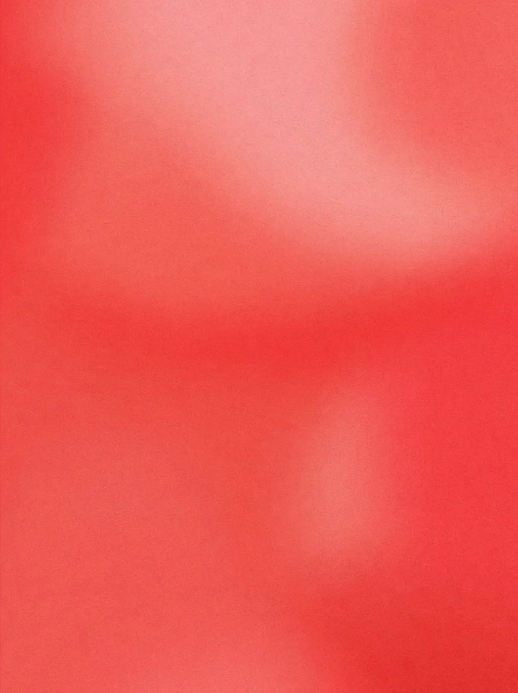 An extremely close-up, blurry image with shades of reddish-pink. No distinguishable objects or details are visible.