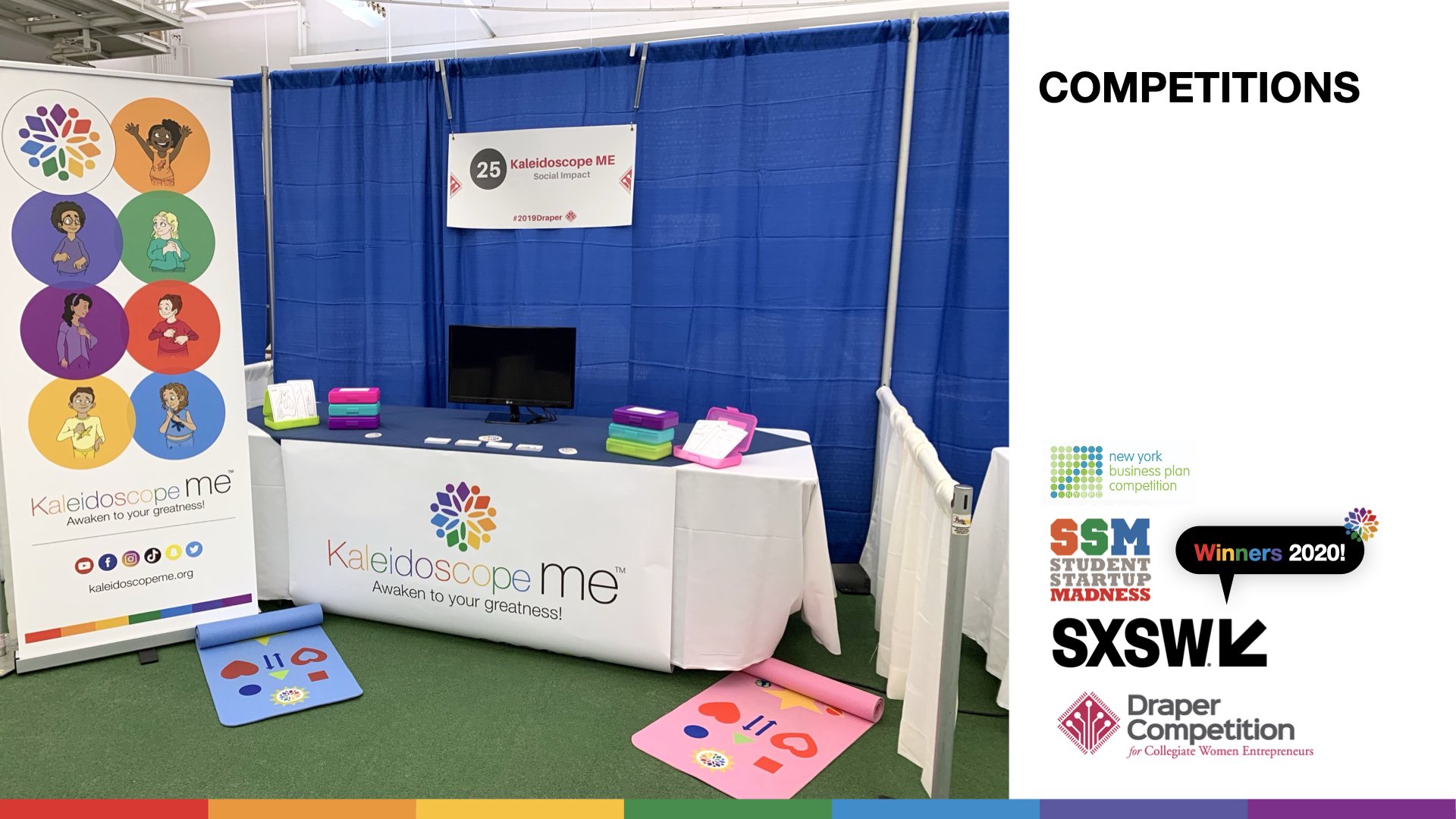 A booth for Kaleidoscope ME, a social impact organization, at the SXSW conference. The booth features a banner with colorful circles and illustrations of diverse children, a table with marketing materials, a monitor, and foam mats on the floor with heart and star drawings.
