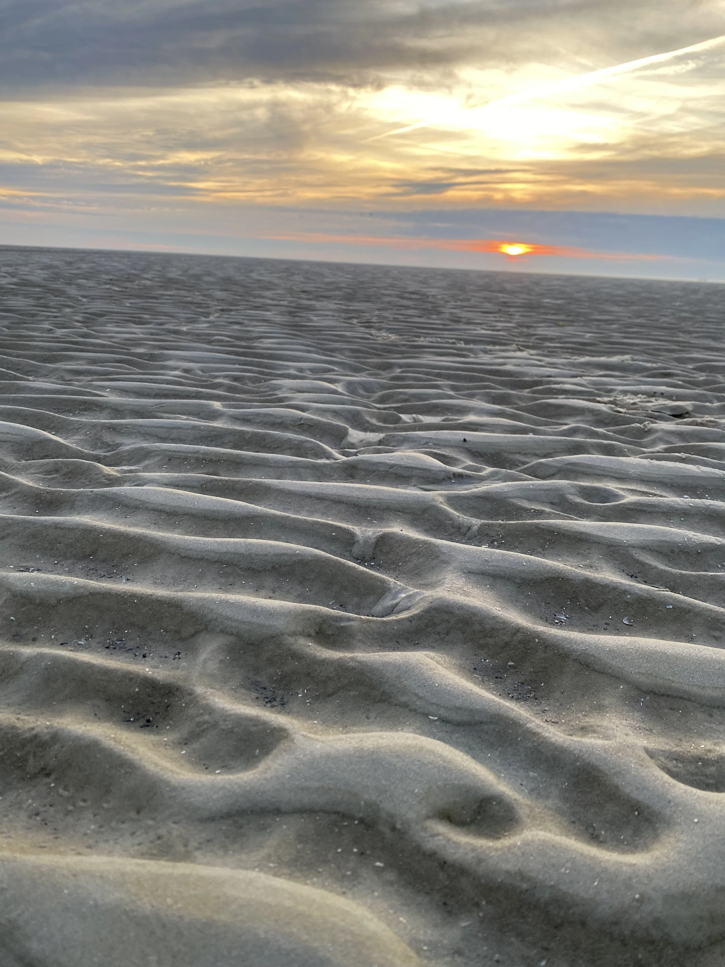 Sanddüne bei Sonnenuntergang mit Himmel und Wolken