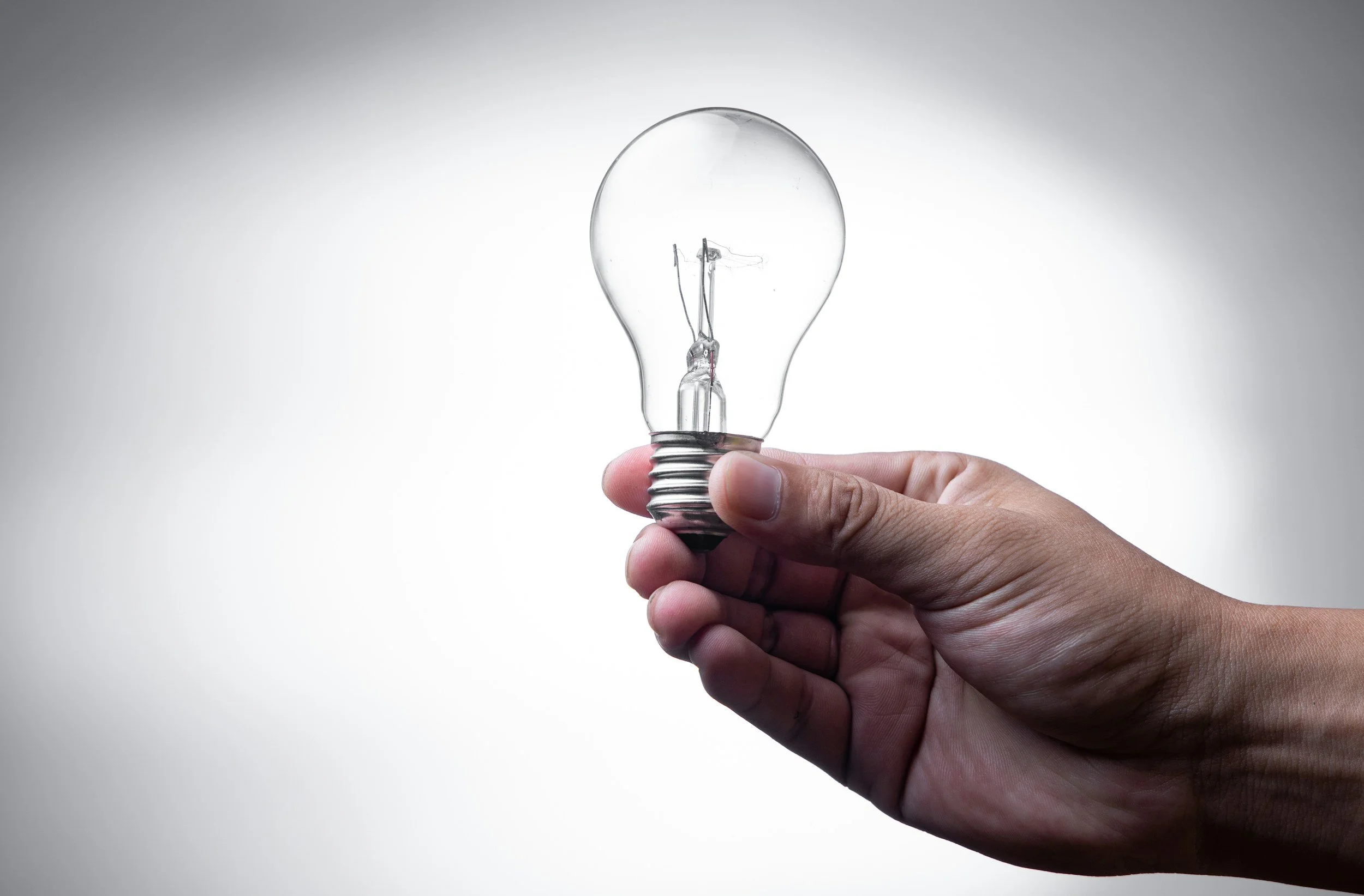 Jesus Cares - Hand holding an incandescent light bulb