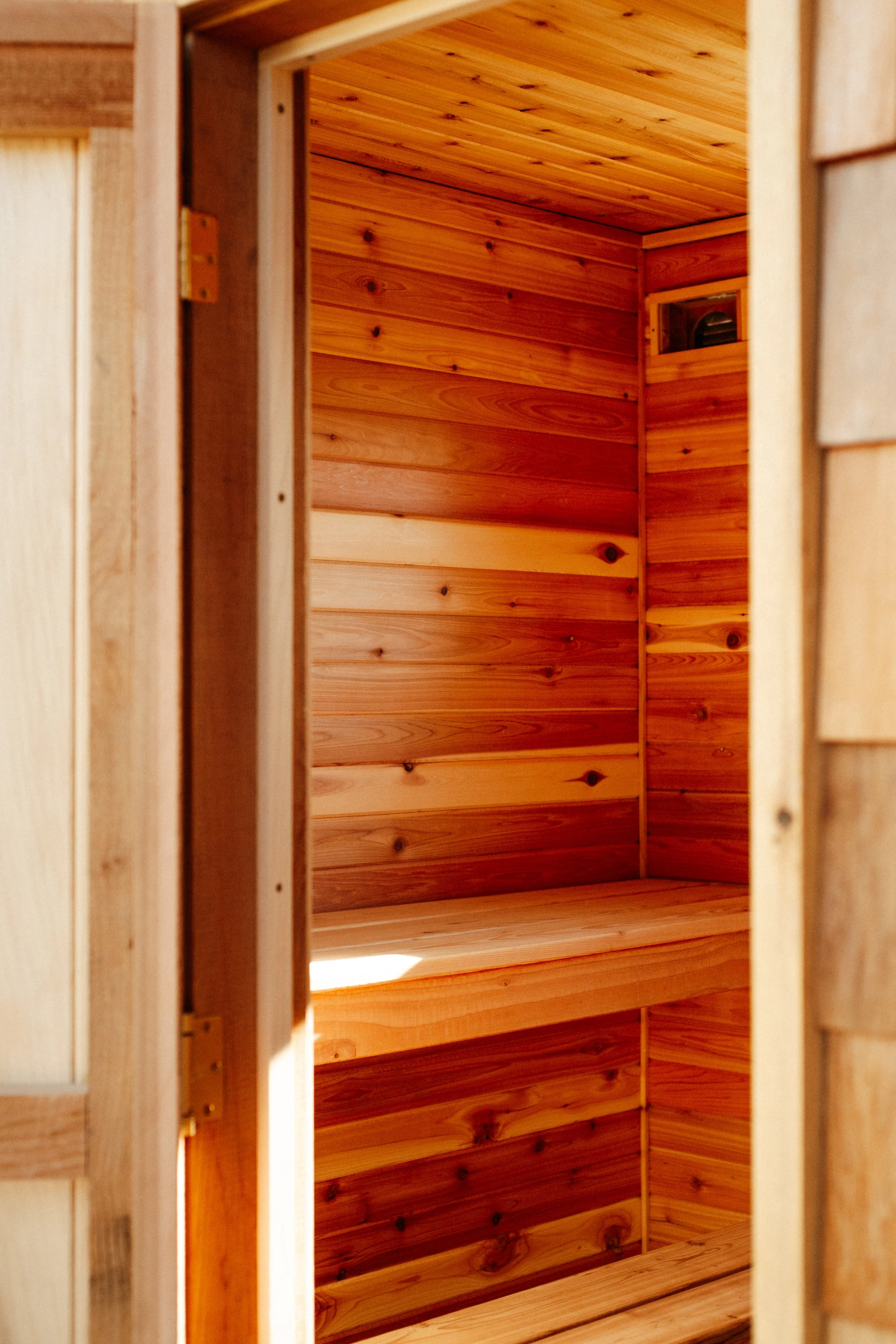Interior of a custom sauna with cedar paneling on the walls and ceiling.