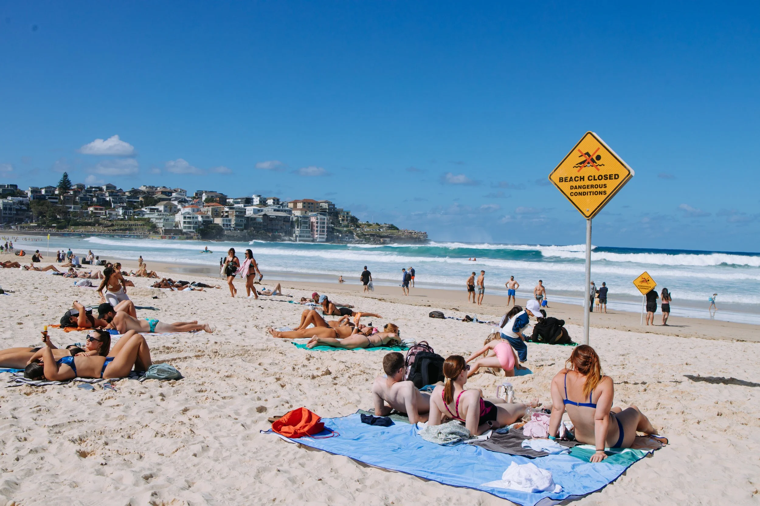 Group of friends relaxing together on a sunny beach during a destination getaway.