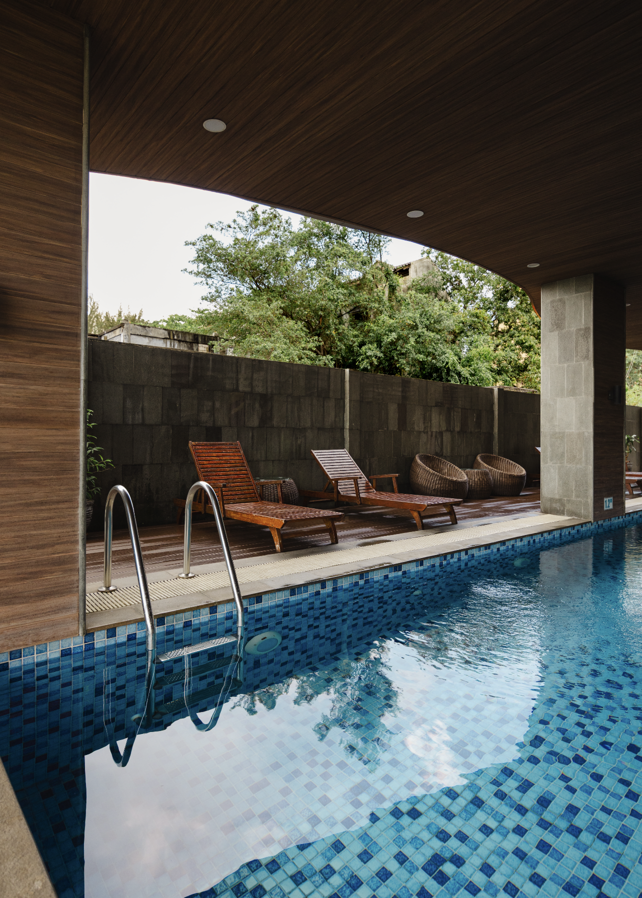 Indoor swimming pool and covered patio photographed for a real estate or hospitality property listing.