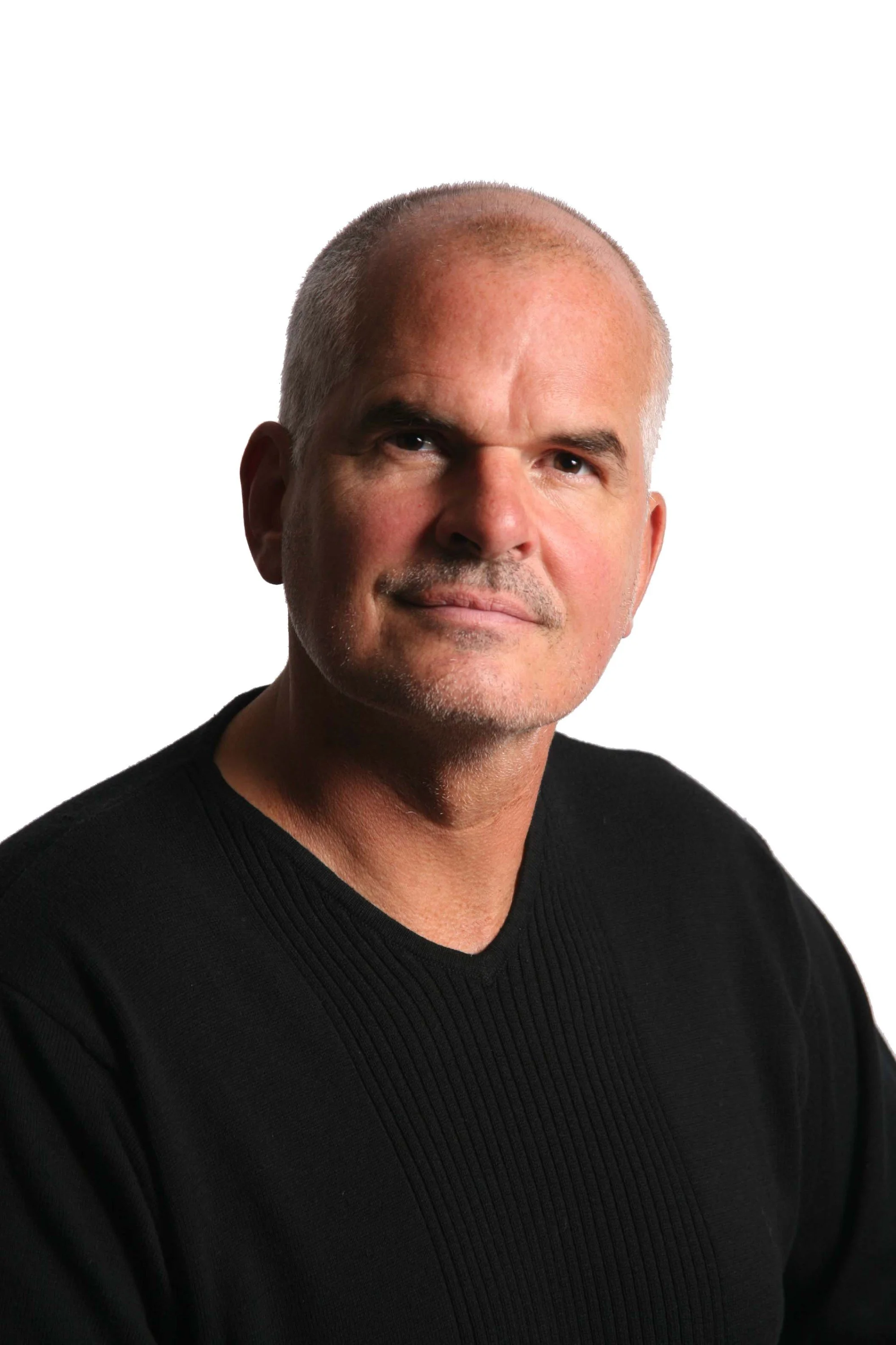 Close-up of a middle-aged man with a shaved head and a light beard, wearing a black sweater, smiling slightly, against a white background.