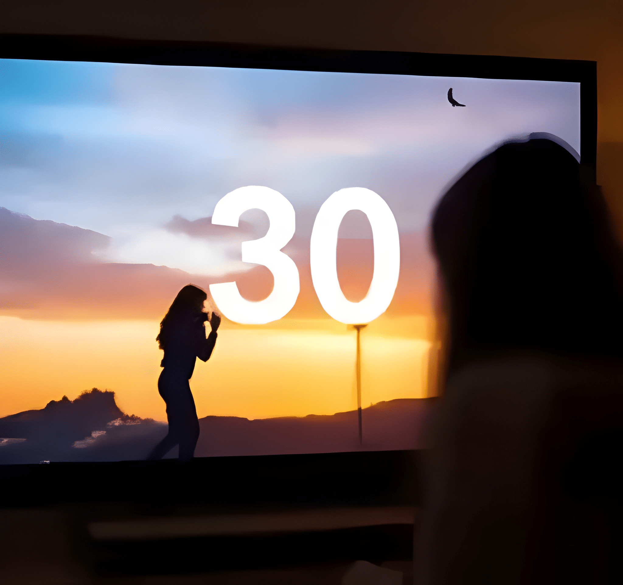 Silhouette of a person taking a photo with a mobile phone during a sunset, with a large illuminated number 30 and a cloudy sky in the background.