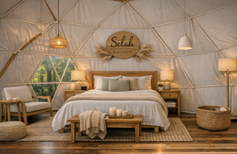 Interior of a cozy bedroom in a glamping tent with a wooden bed, nightstands, and woven decor, at Selah Micro Resort.