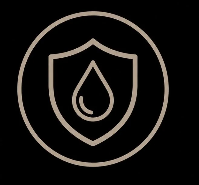 An icon of a shield with a droplet in the center, all outlined in beige on a black background.
