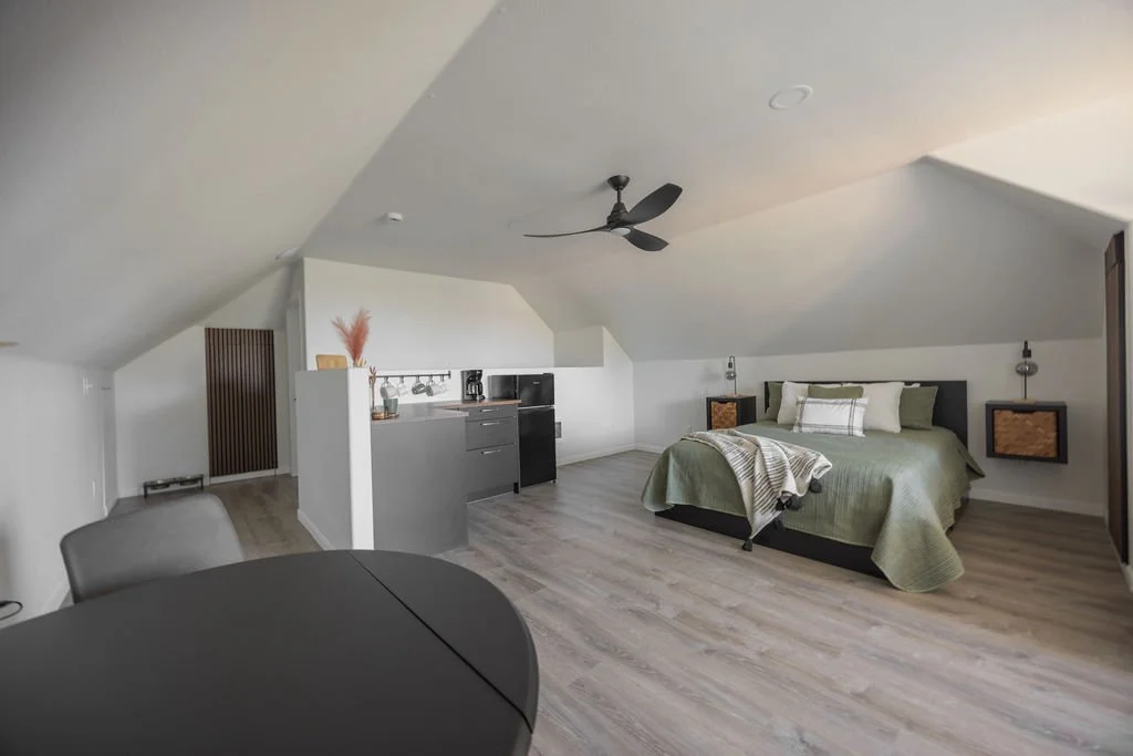 guest loft bedroom kitchenette and eating area with sloped ceiling and half wall