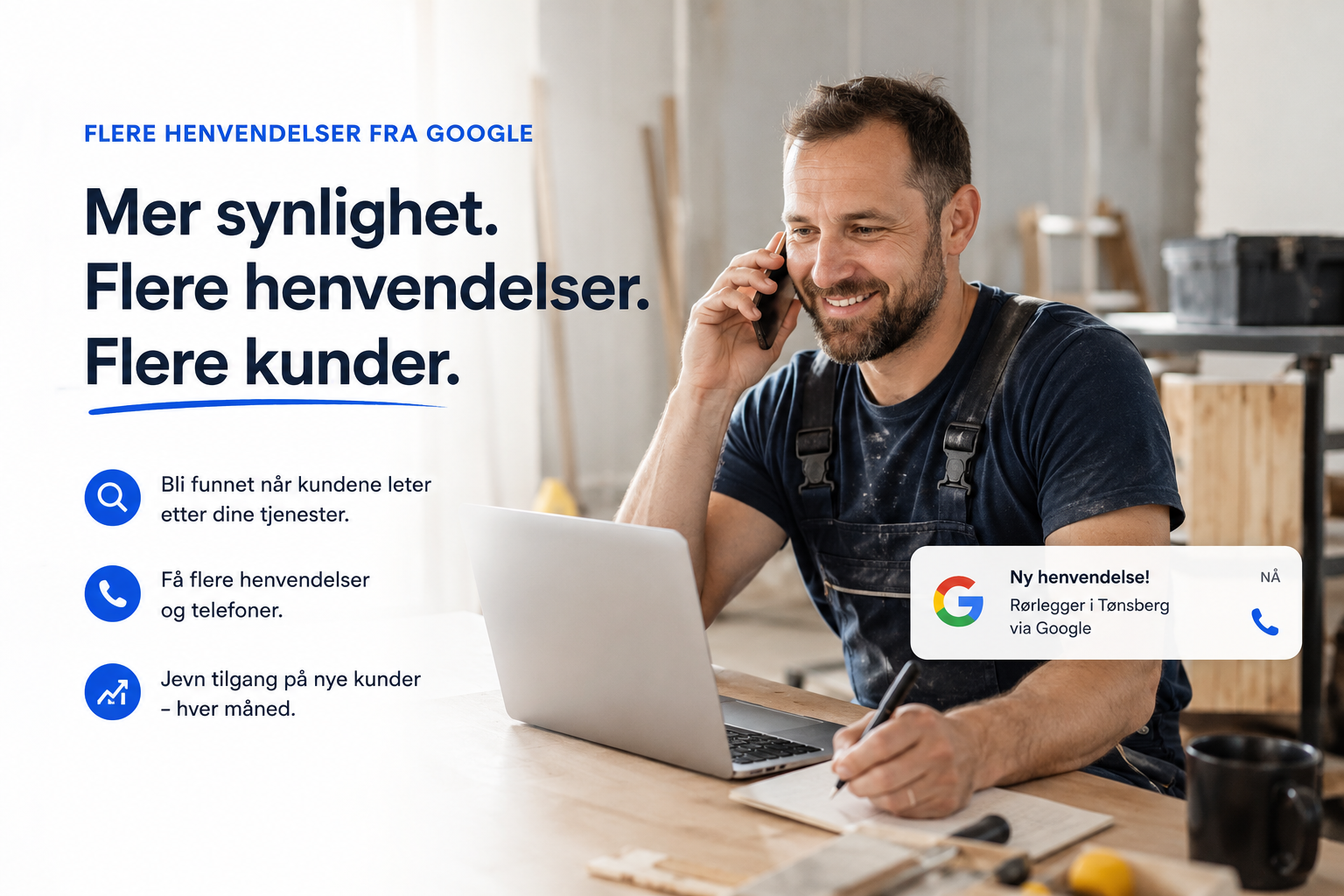 En mann som smiler og snakker i telefonen mens han sitter ved et bord med en åpen laptop og notatpapir. Han er iført arbeidsklær og er i et rom som ser ut som et verksted eller et arbeidsområde.