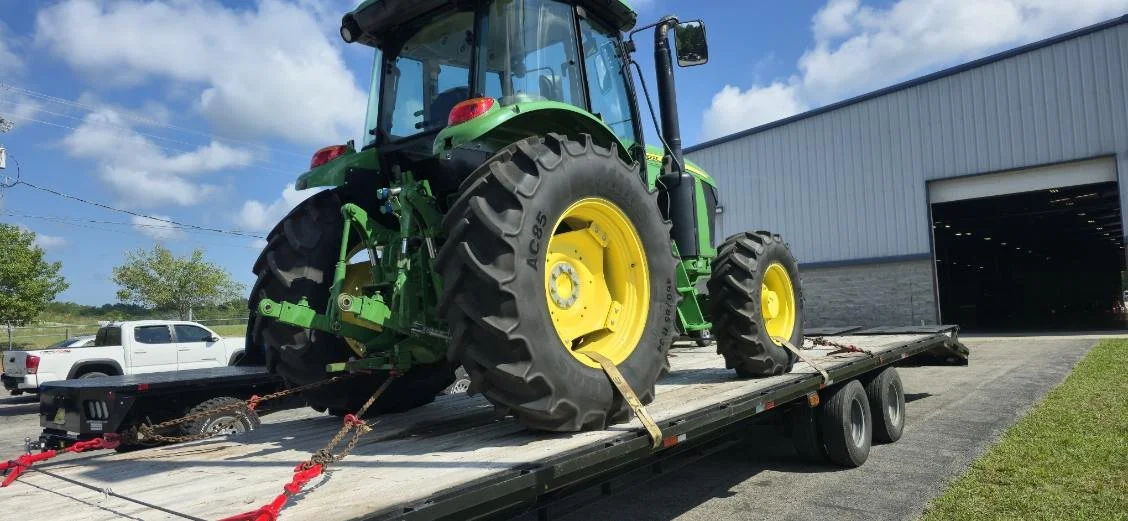 John Deere tractor loaded on flatbed trailer for heavy equipment transport – Prime Load Solutions