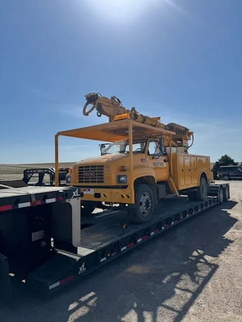 Crane truck on flatbed trailer hauled on highway – Prime Load Solutions heavy haul