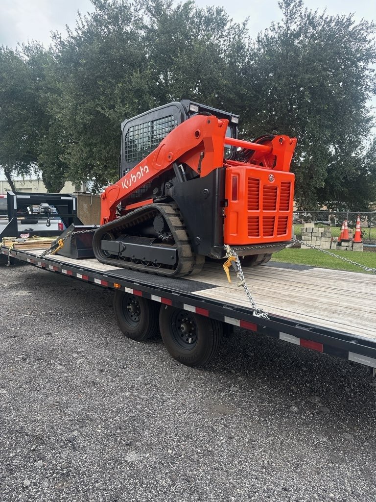 Kubota mini excavator secured on flatbed trailer for hotshot transport – Prime Load Solutions