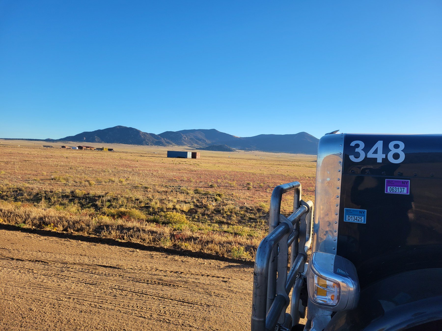 Prime Load Solutions LLC flatbed truck transporting heavy equipment across the USA